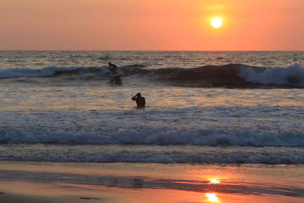 Surfen bei Sonnenuntergang in Montañita, Santa Elena.