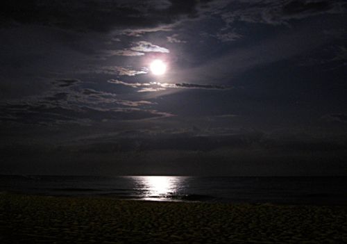 A reflection of the moon in the water on the beach at Castelldefels